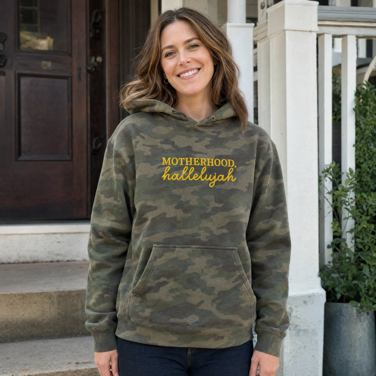 Model wearing the Motherhood Hallelujah heavyweight hoodie in Green Camo, lifestyle image 1