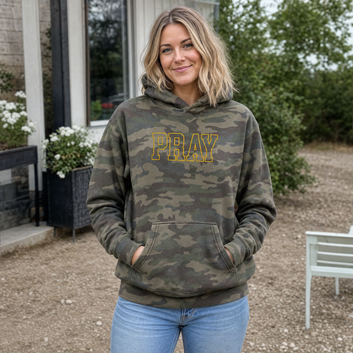 Model wearing the Pray Outline Text heavyweight hoodie in Green Camo, lifestyle image 1