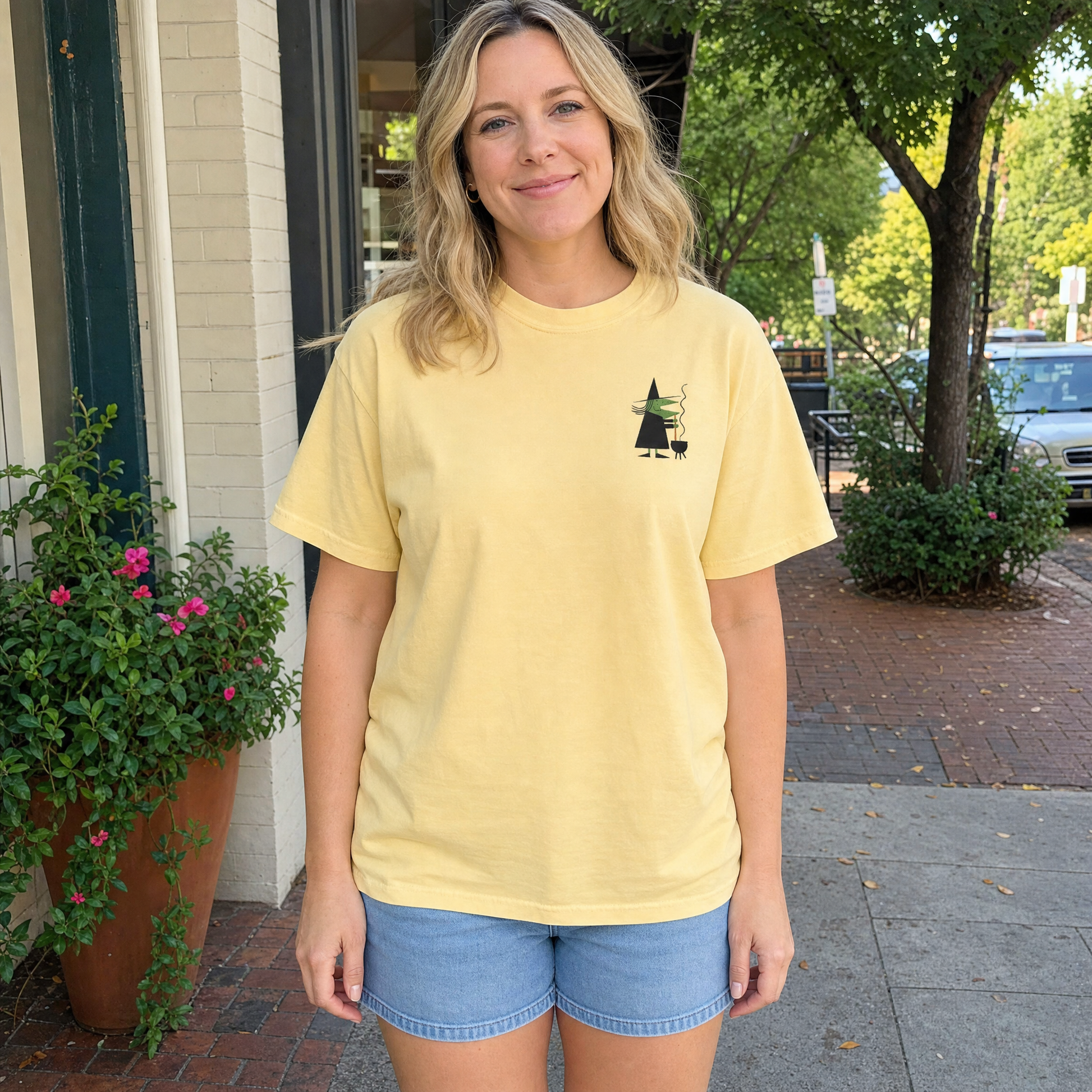 Model wearing the Retro Witch Stirring Cauldron comfort colors tee in Butter, lifestyle image 1