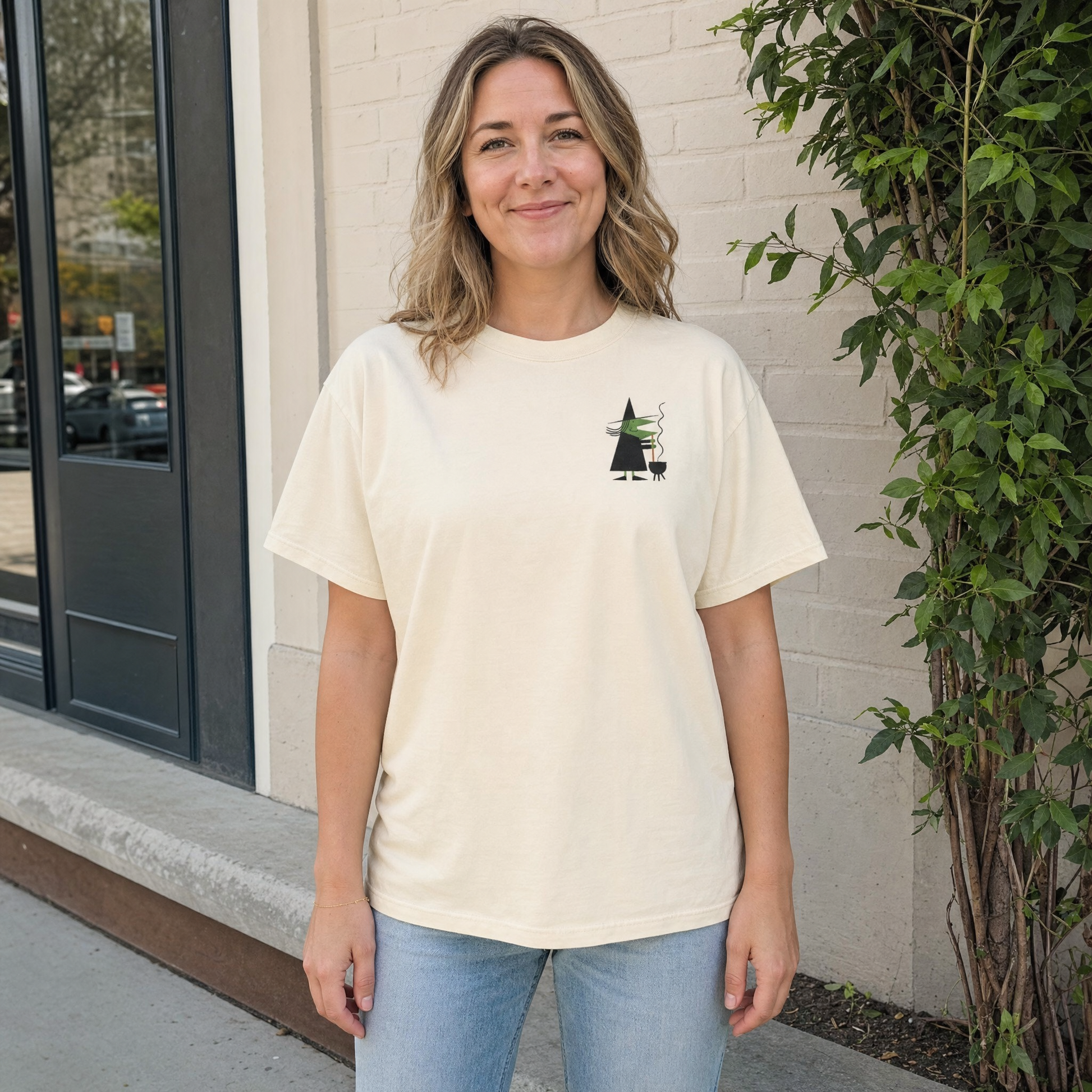 Model wearing the Retro Witch Stirring Cauldron comfort colors tee in Ivory, lifestyle image 1