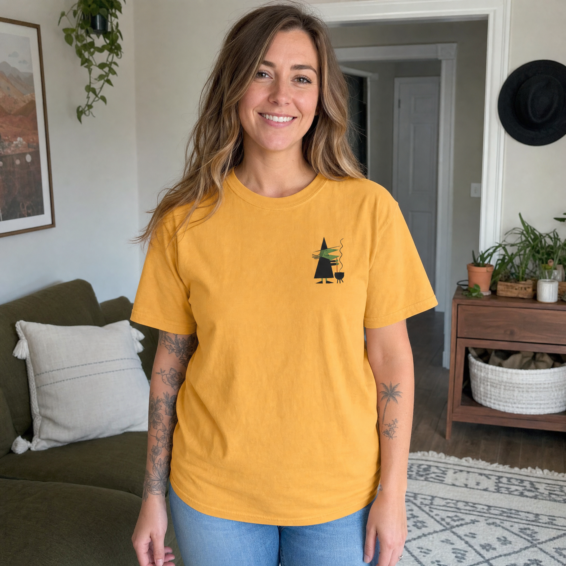 Model wearing the Retro Witch Stirring Cauldron comfort colors tee in Mustard, cover image 1