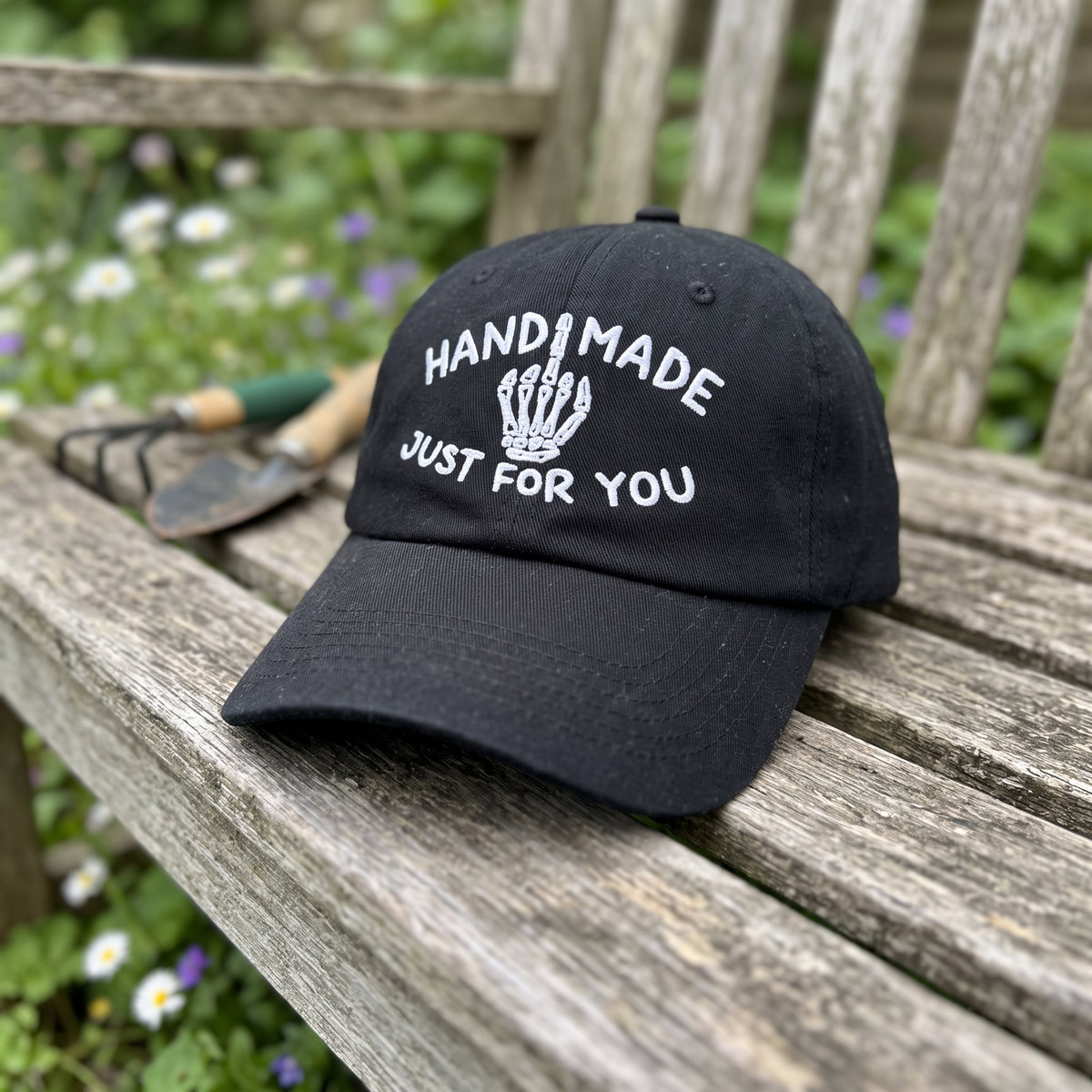 Skeleton Middle Finger embroidered hat in Black resting on a flat surface, lifestyle image 1