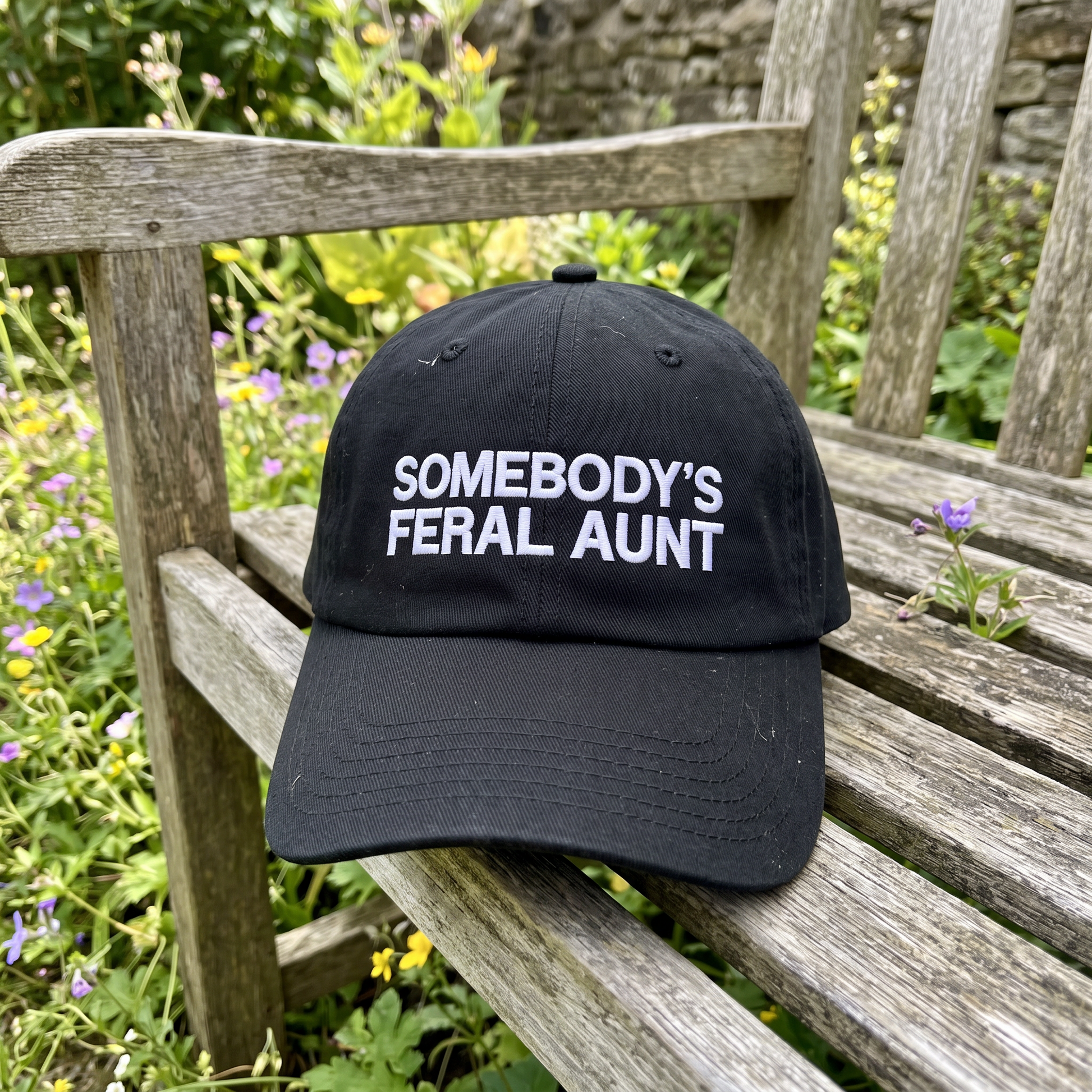 Somebody's Feral Aunt embroidered hat in Black resting on a flat surface, lifestyle image 1