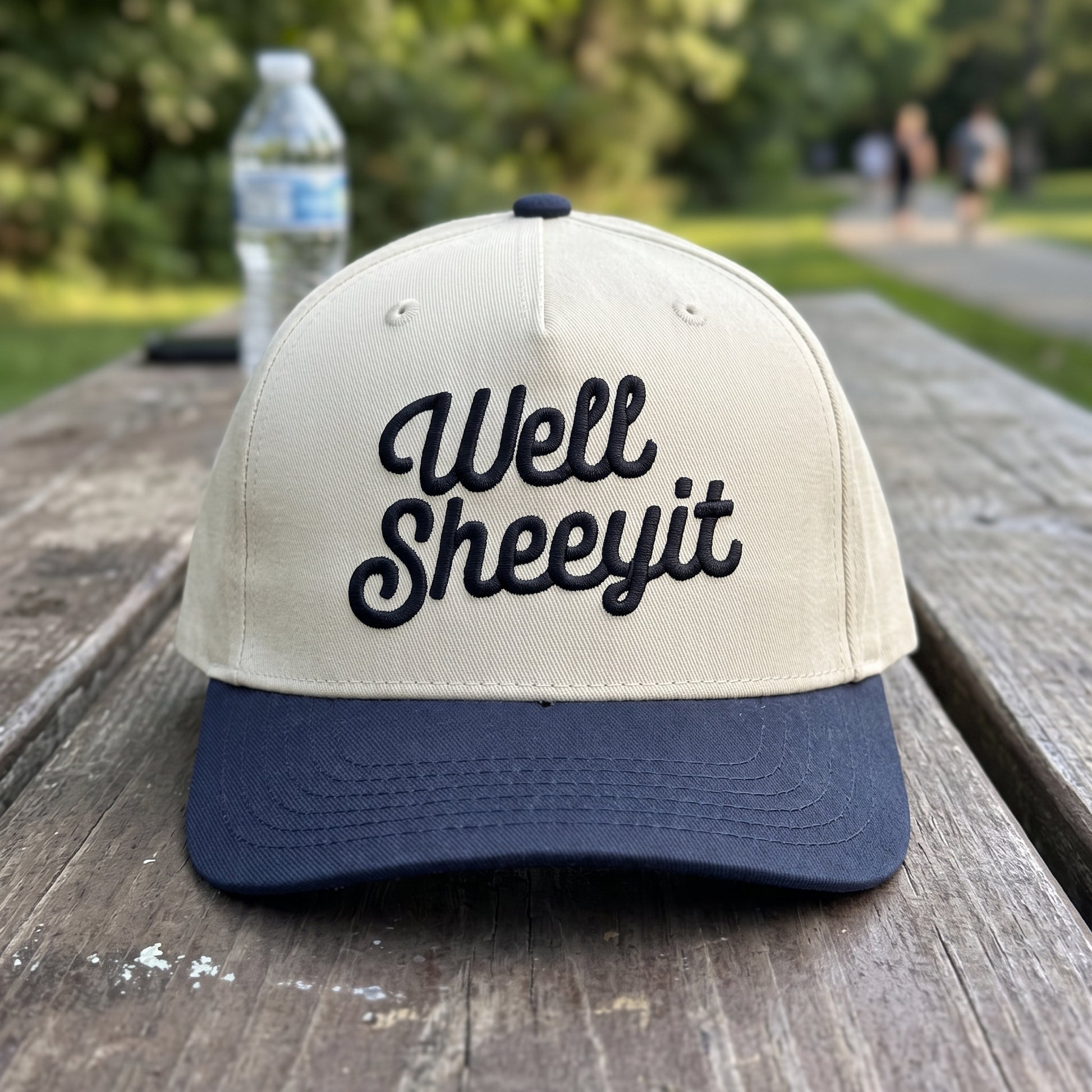 Well Sheeyit Southern Accent embroidered hat in Navy/natural resting on a flat surface