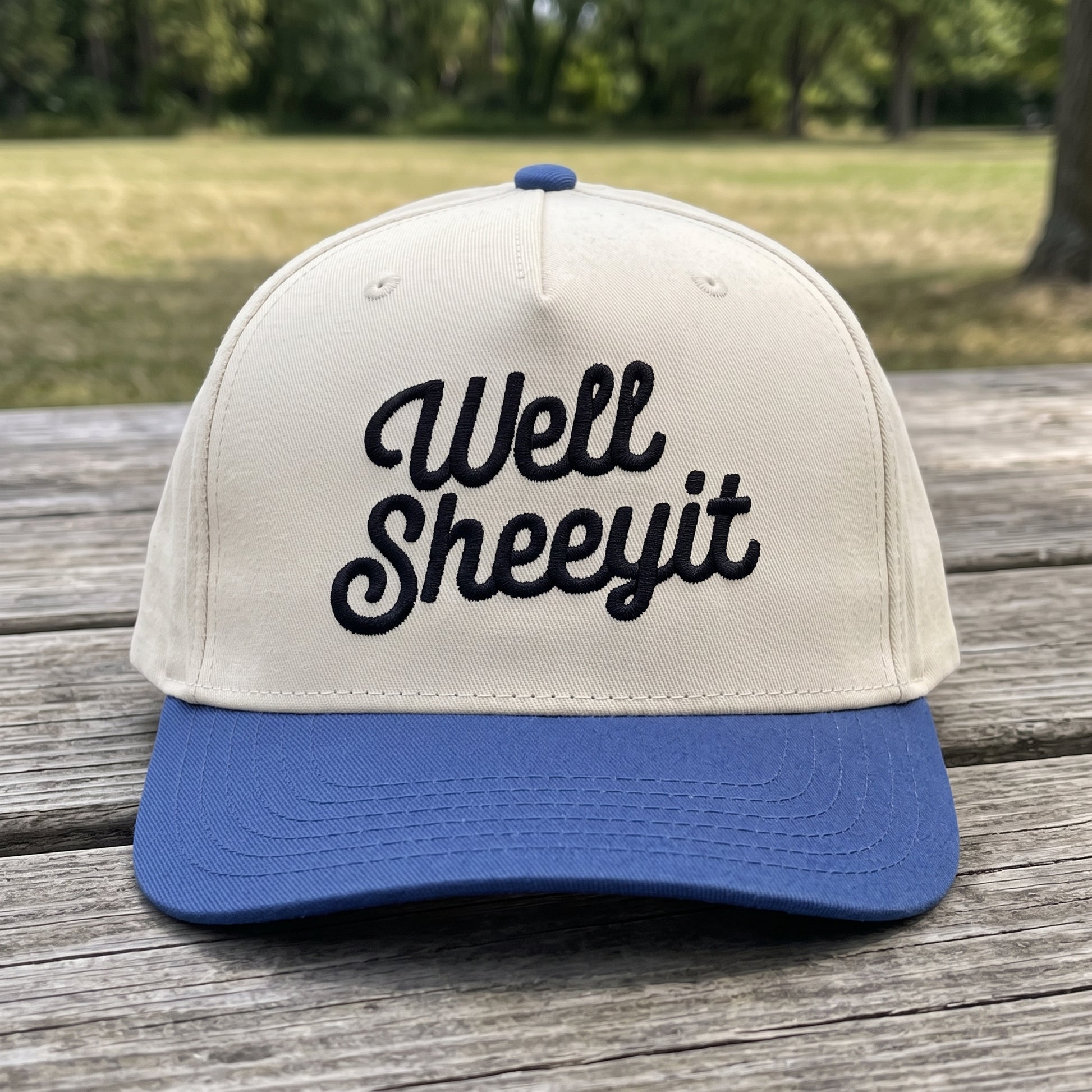 Well Sheeyit Southern Accent embroidered hat in Royal/natural resting on a flat surface