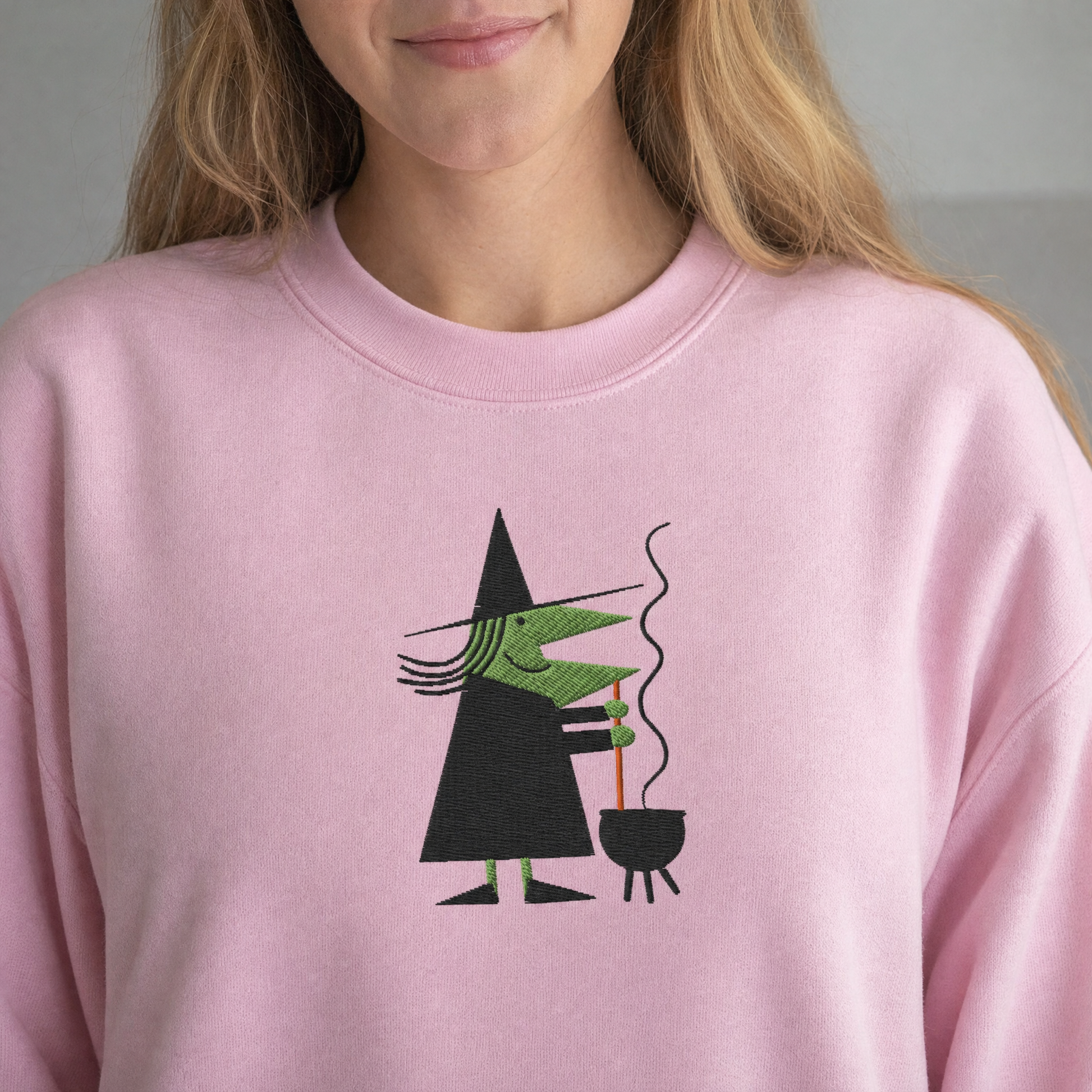 Model wearing the Witch Stirring Cauldron sweatshirt in Light Pink, lifestyle image 2