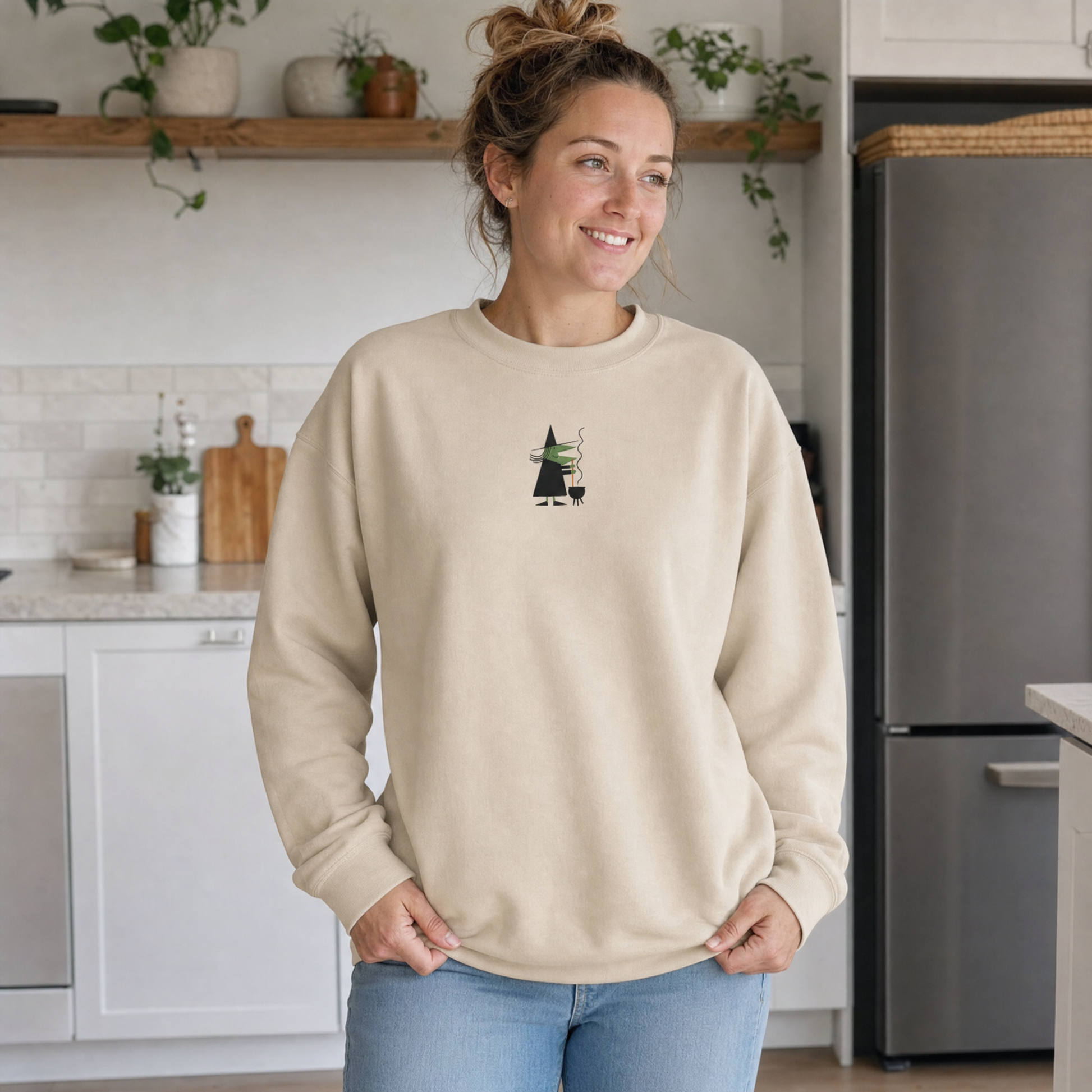 Model wearing the Witch Stirring Cauldron sweatshirt in Sand, lifestyle image 1