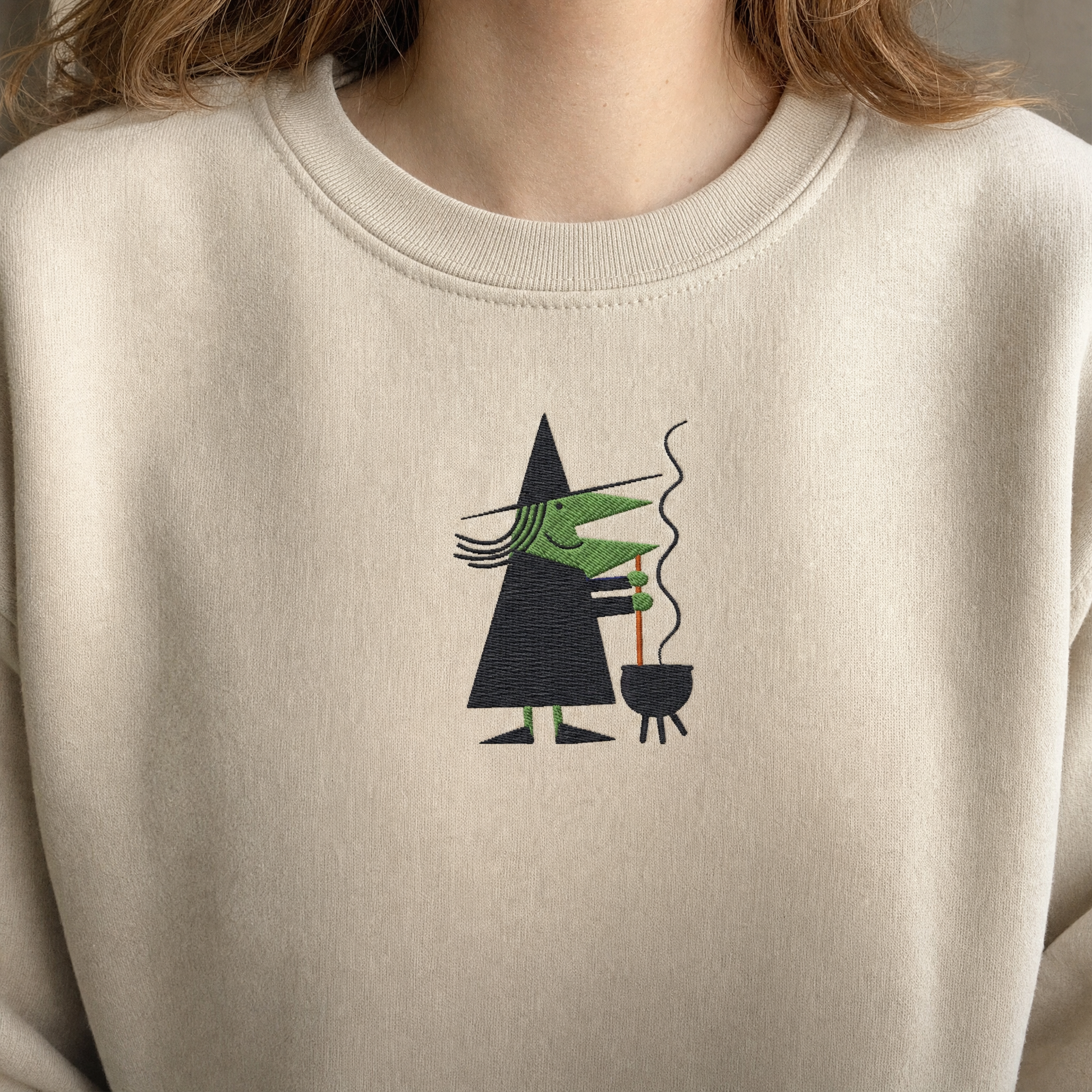Model wearing the Witch Stirring Cauldron sweatshirt in Sand, lifestyle image 2