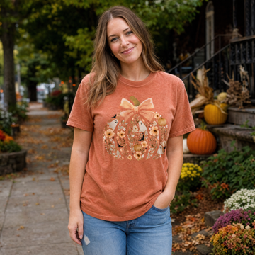Model wearing the Floral Pumpkin comfort colors tee in Yam