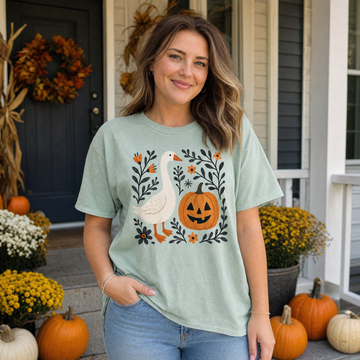 Model wearing the Goose Jack-o'-lantern comfort colors tee in Bay