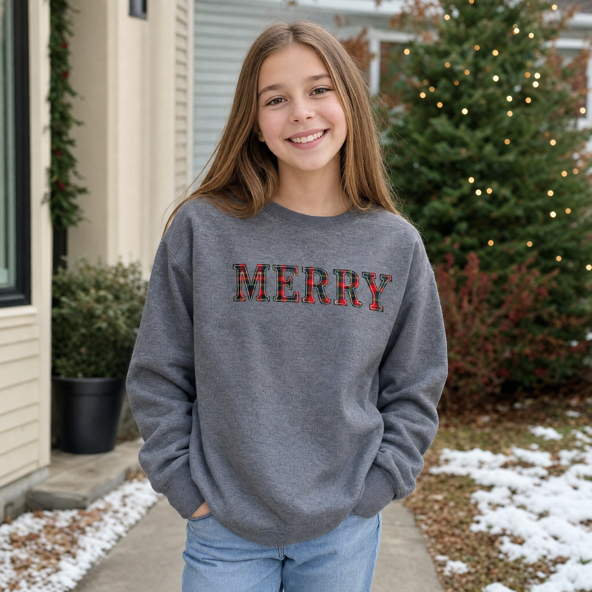Model wearing the Merry Plaid Text youth sweatshirt in Dark Heather