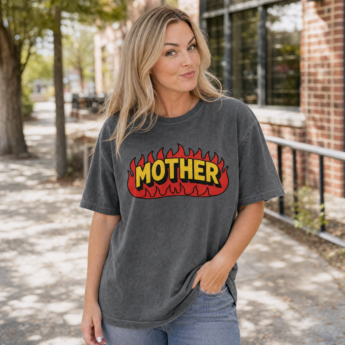 Model wearing the Mother Flaming Text comfort colors tee in Pepper, lifestyle image 1