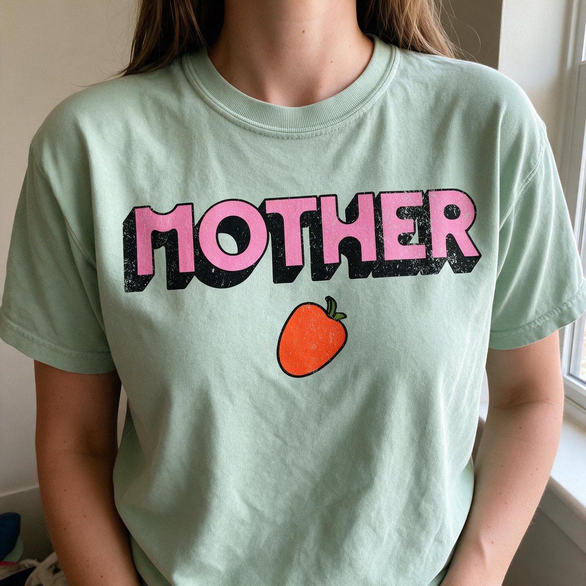 Model wearing the Mother Strawberry comfort colors tee in Bay