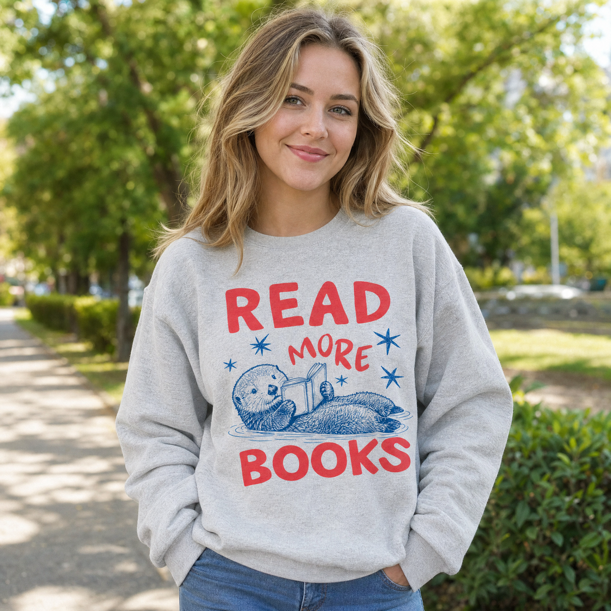 Model wearing the Otter Reading Book sweatshirt in Ash, lifestyle image 1