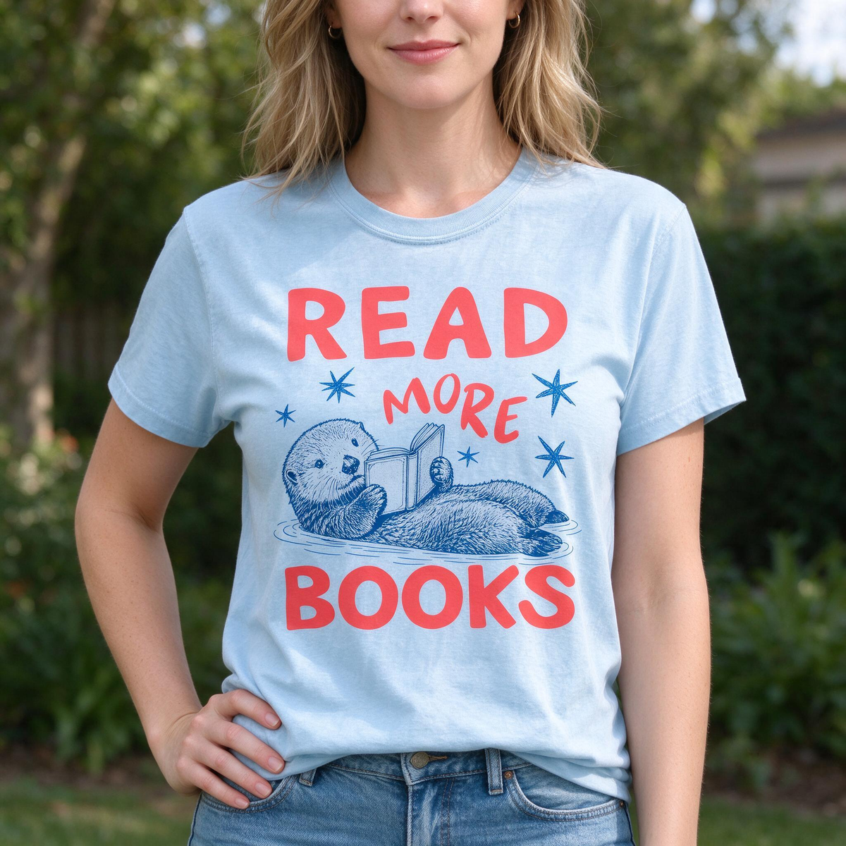Model wearing the Otter Reading Book comfort colors tee in Chambray