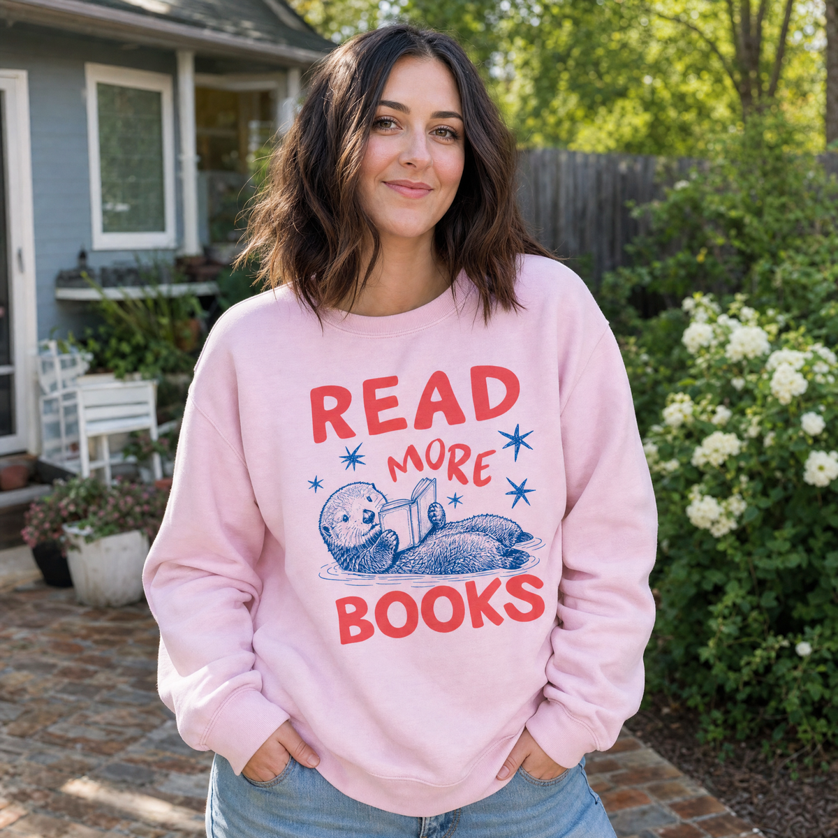 Model wearing the Otter Reading Book sweatshirt in Light Pink
