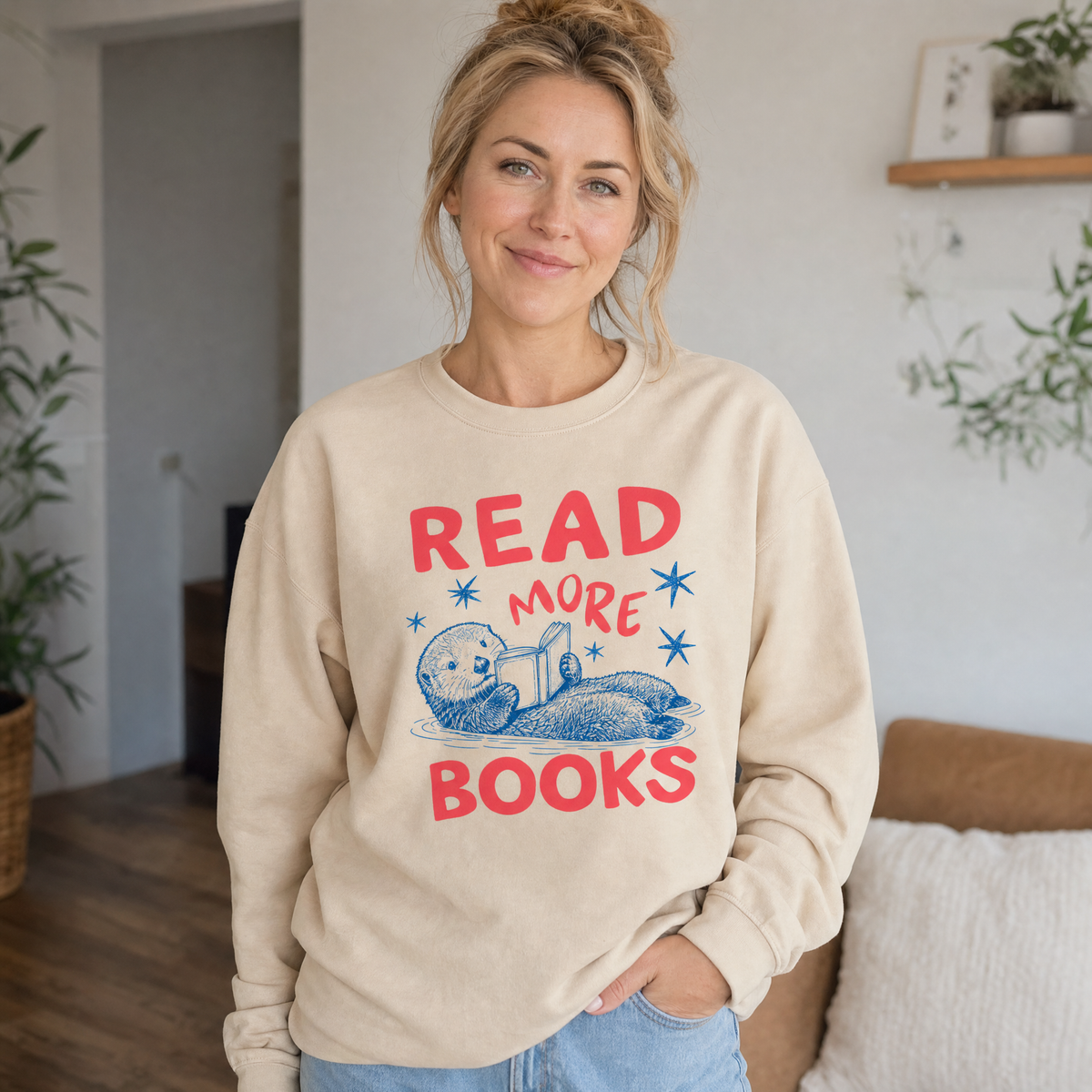 Model wearing the Otter Reading Book sweatshirt in Sand