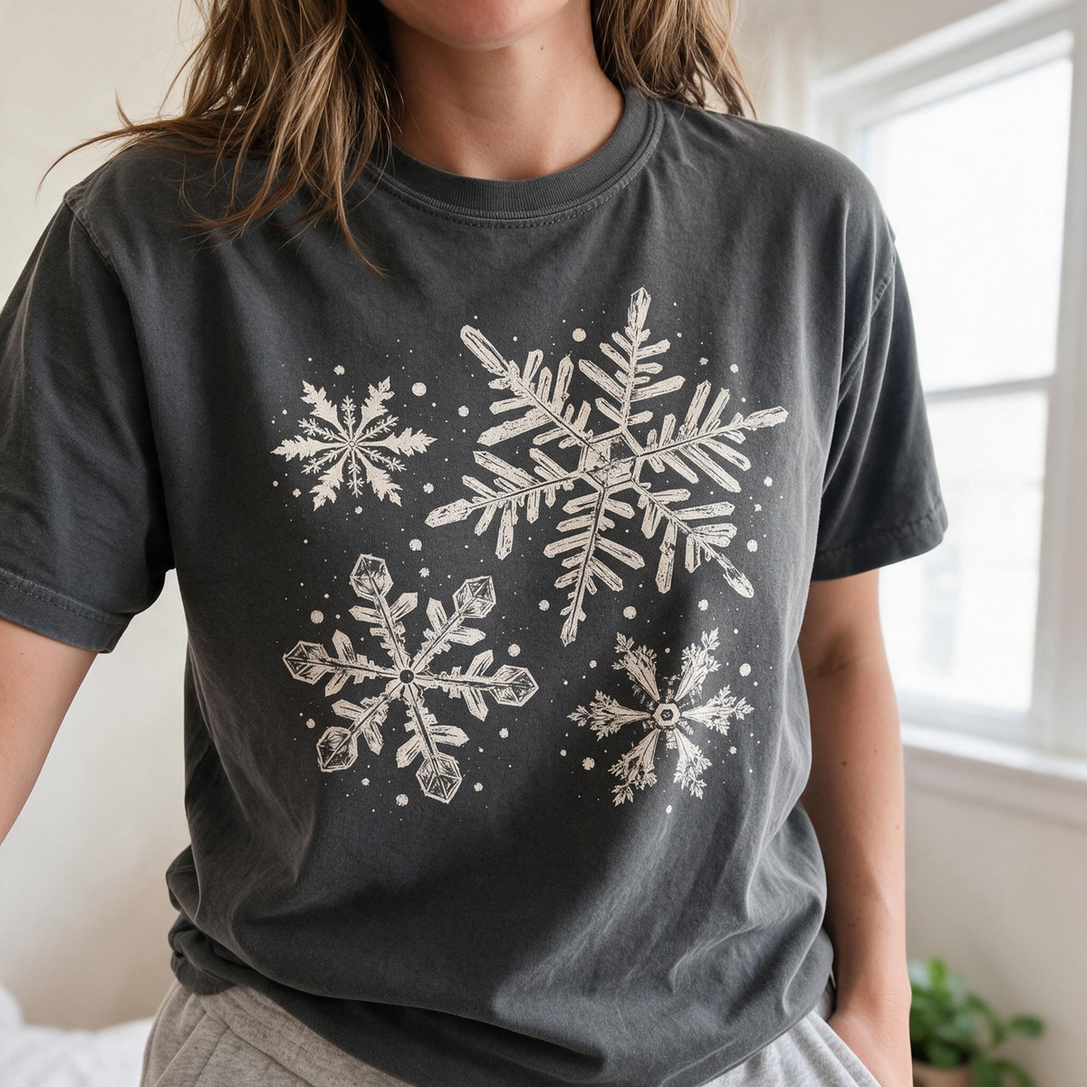 Model wearing the Snowflakes comfort colors tee in Pepper, lifestyle image 1