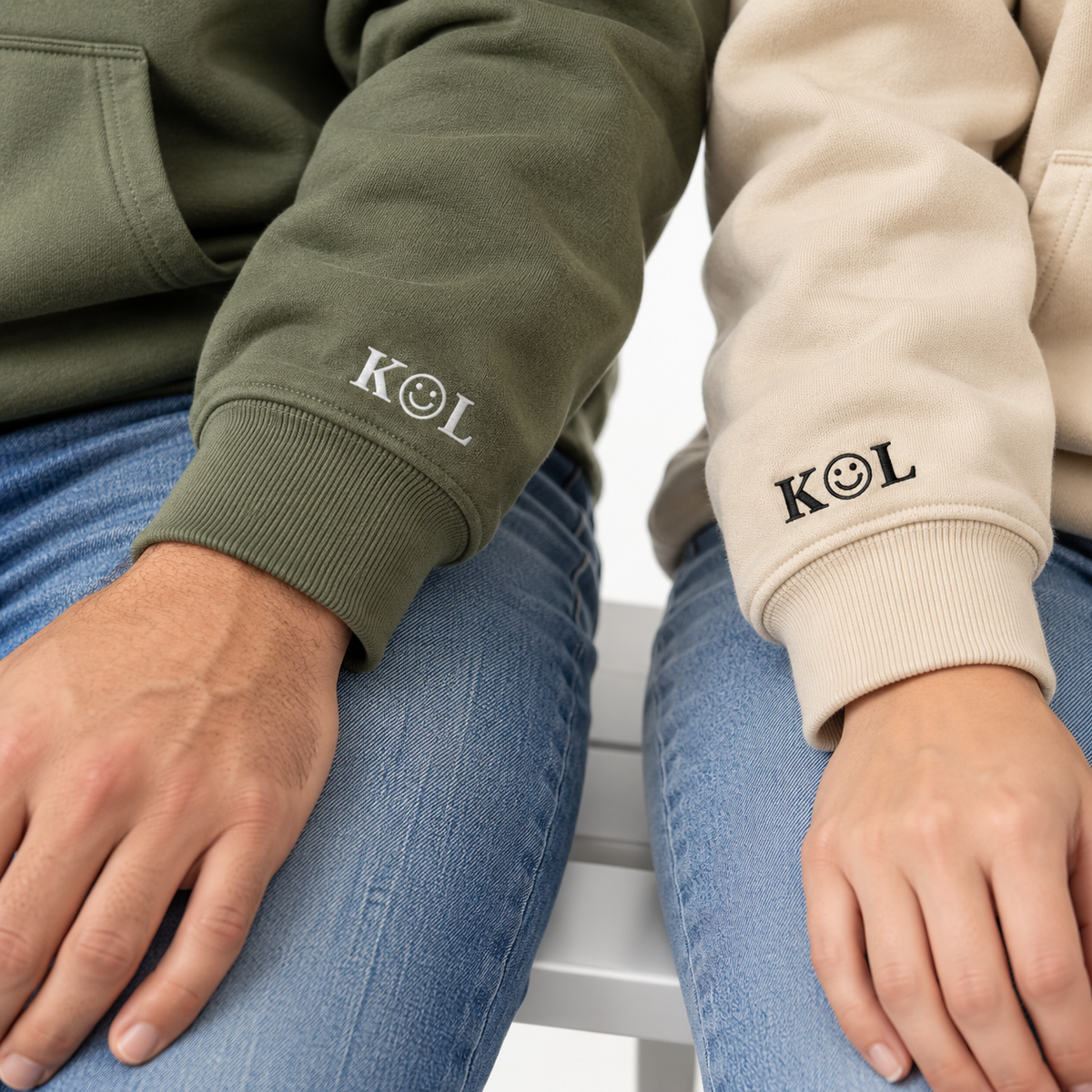Lifestyle close-up of K smiley L on Military Green and Sand hoodie sleeves.